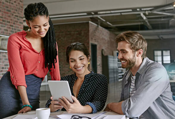  Imagen de dos mujeres y un hombre sentados, con una tableta. Descubriendo el programa de Recompensas Amway.