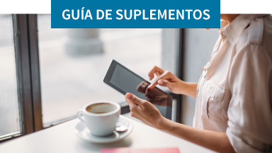 Mujer utilizando una table mientras está tomando un café. Encuentra los suplementos adecuados para ti.